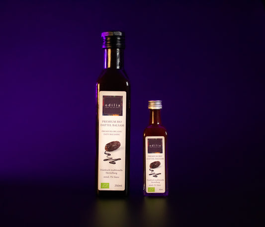 Eine Flasche des exklusiven Premium Bio Dattel Balsams - ein edelwürziges Produkt aus reifen Datteln und sorgfältig ausgewählten, erlesenen Gewürzen in Bio-Qualität von odilia.