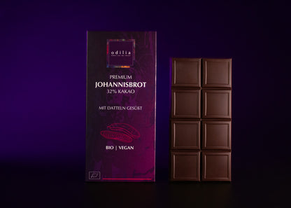 Einige attraktiv arrangierte, angebrochene Stücke der knackigen Premium Johannisbrot Schokolade.