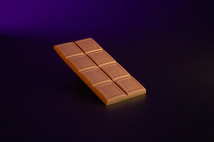 Die ausgepackte 70g Tafel der Premium Pistazie-Orange Schokolade mit den eingearbeiteten Pistazien und Orangenstückchen.